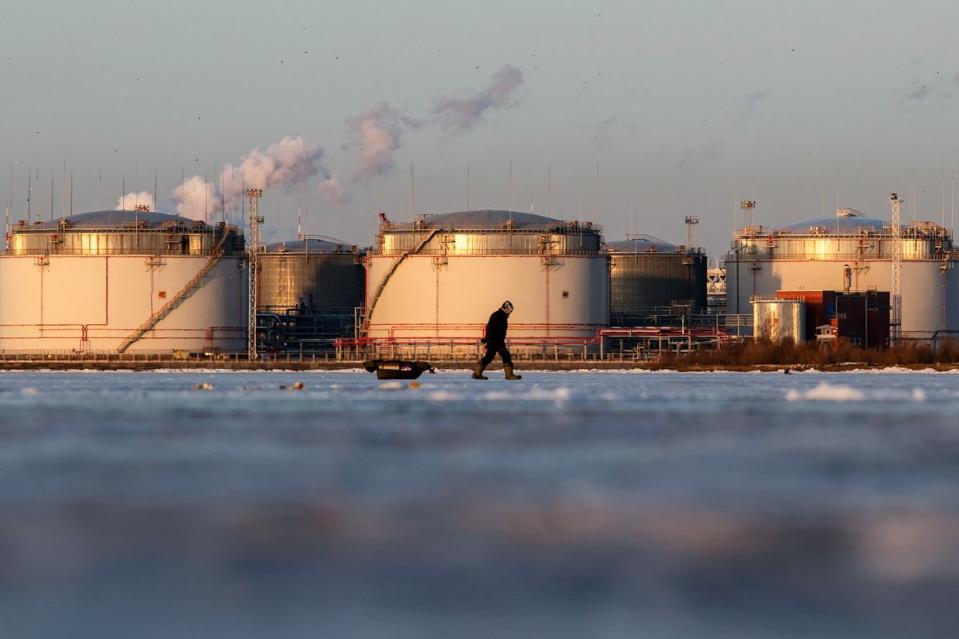 A fisherman carries his belongings on a sleigh on the ice of the Gulf of Finland against the backdrop of the St. Petersburg Oil Terminal in St. Petersburg. (Artem Priakhin/SOPA Images/LightRocket via Getty Images)