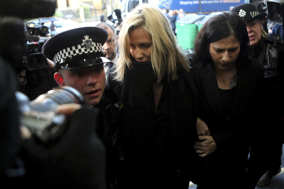 FILE - In this file photo dated Monday, Dec. 23, 2019, Love Island TV presenter Caroline Flack, centre, is escorted by police as she arrives at court in London, after being charged with assault of former professional tennis player and model Burton. The host of controversial reality TV show “Love Island,” has died aged 40, according to a statement from her family Saturday Feb. 15, 2020. (AP Photo/Petros Karadjias, FILE)