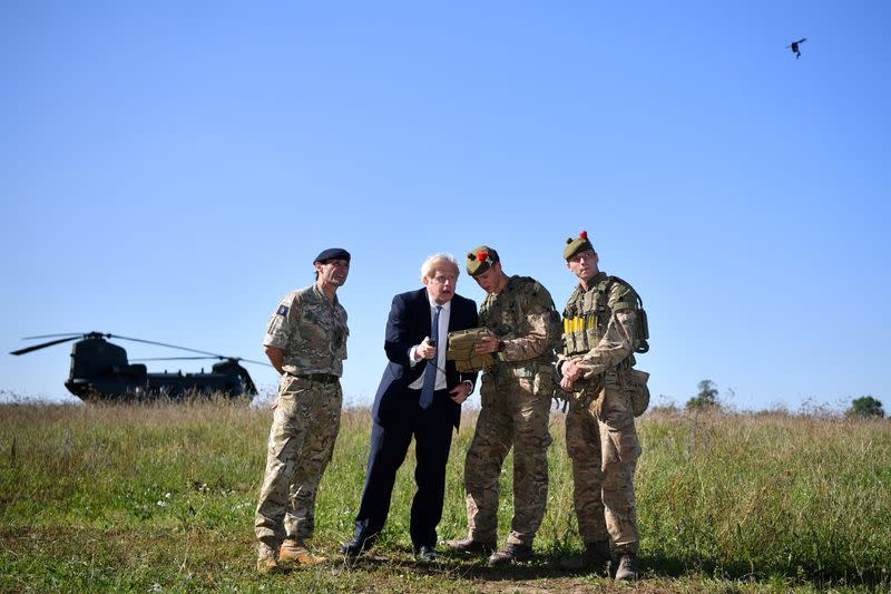 Britain's Prime Minister Boris Johnson flies a Black Hornet nano drone during a meeting with military personnel on Salisbury plain training area near Salisbury