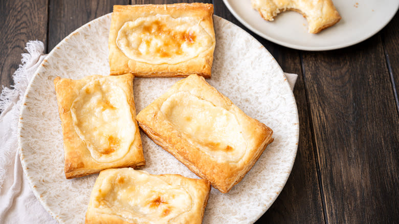 four cream cheese danishes on ceramic plate