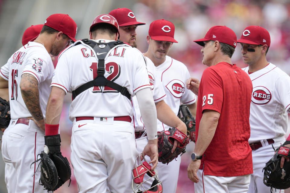 Cincinnati Reds manager David Bell (25) speaks with starting pitcher Graham Ashcraft, center, on the mound during the third inning of a baseball game against the Milwaukee Brewers in Cincinnati, Saturday, June 3, 2023. (AP Photo/Jeff Dean)