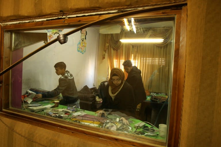 Palestinian journalists check the damage after Israeli security forces entered the offices of the Palestinian Dream radio and handed the station a six-month broadcasting ban on November 29, 2015