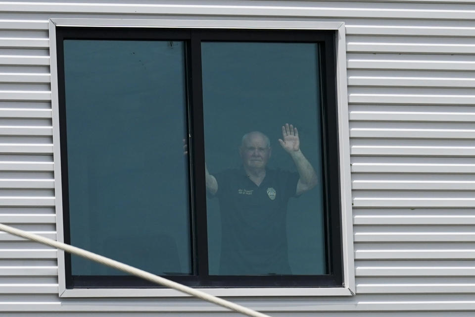 Grand Isle Police Chief Chief Scooter Resweber waves from a window in the building where he rode out the hurricane with police and fire personnel, in the aftermath of Hurricane Ida in Grand Isle, La., Tuesday, Aug. 31, 2021. He has not left the island, as it is accessible only by boat or helicopter.(AP Photo/Gerald Herbert)