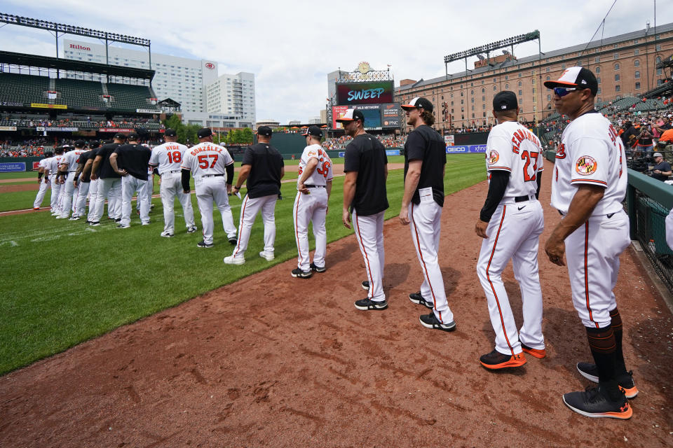 Baltimore Orioles players gather on the field after defeating the Los Angeles Angels during a baseball game, Sunday, July 10, 2022, in Baltimore. The Orioles won 9-5 to sweep the series. (AP Photo/Julio Cortez)