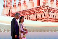 FILE PHOTO: Myanmar leader Aung San Suu Kyi and Singapore's Prime Minister Lee Hsien Loong leave the opening ceremony of ASEAN Summit in Vientiane