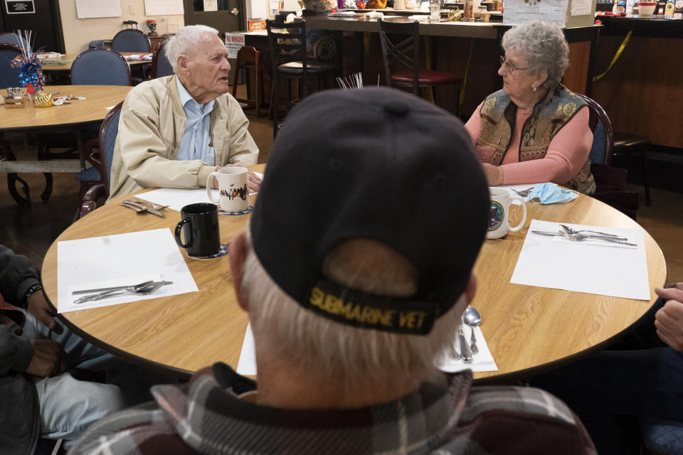 Pearl Harbor survivor and World War II Navy veteran David Russell, 101, left, talks with Karen Wilson, right, and other veterans while eating breakfast at the American Legion Post 10 on Monday, Nov. 22, 2021, in Albany, Ore. (AP Photo/Nathan Howard)