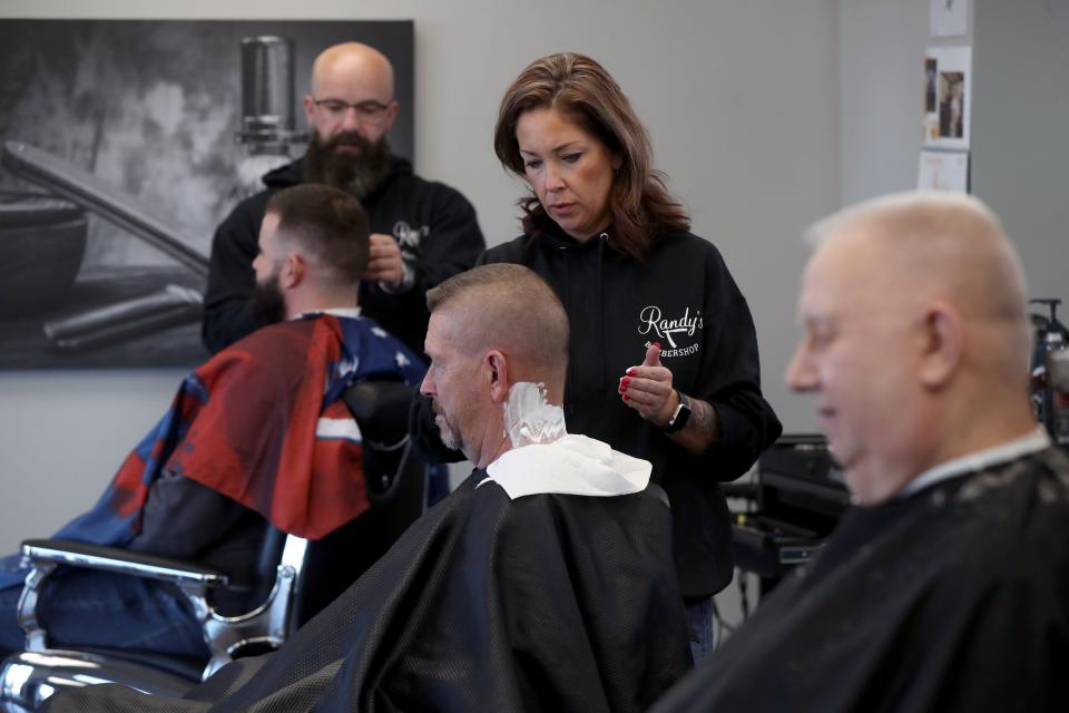 Barber Lisa Herrmann lathers Jacksontown resident Doug Lampron's neck for a shave Nov. 9 at Randy's Barbershop in Pickerington.