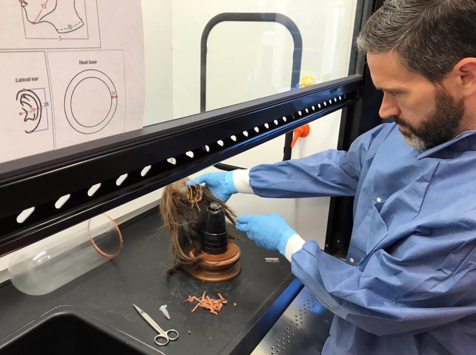 Mercer University biologist and anthropologist Craig Byron examines the tsantsa to verify its authenticity before it was repatriated to Ecuador. (Adam Kiefer)