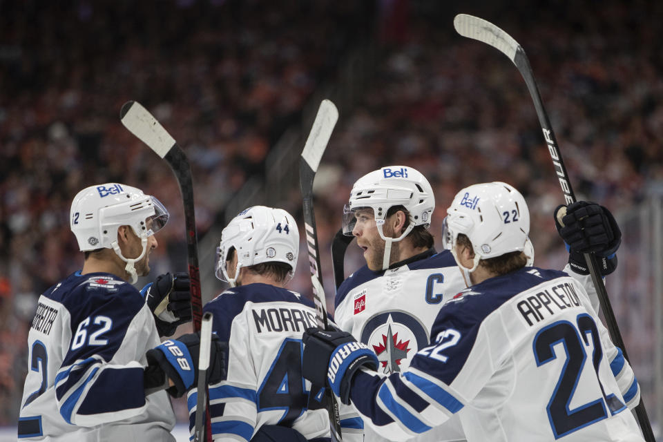 Winnipeg Jets' Adam Lowry, second right, celebrates his goal against the Edmonton Oilers with Nino Niederreiter (62) Josh Morrissey (44) and Mason Appleton (22) during the first period of an NHL hockey game, Wednesday, Oct. 9, 2024 in Edmonton, Alberta. (Amber Bracken/Canadian Press via AP)