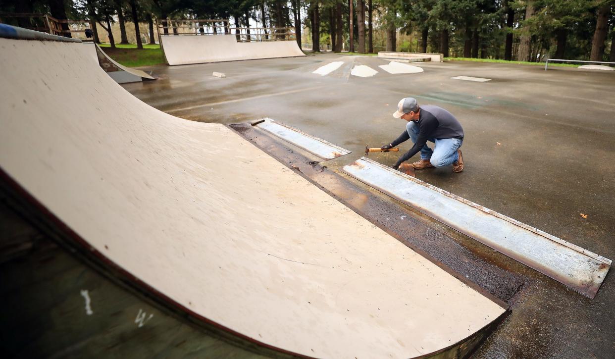 Poulsbo Skate Park Community Coalition member Erik Payne removes the metal edging of the ramps to set aside to be reused in a rebuilt skate park after the closure of the current one at Raab Park on March 25.