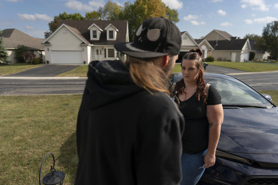 Peer support worker Jesse Johnson of the Family Resource Center looks to her client Tyler Baker as they talk in the driveway of Baker's home in Findlay, Ohio, Thursday, Oct. 12, 2023. Peer support services for people in recovery are a major component of Hancock County's strategy for addressing the opioid epidemic. (AP Photo/Carolyn Kaster)