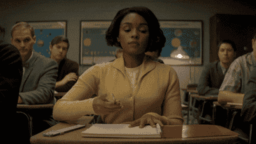 Janelle Monáe writing in a notebook in Hidden Figures