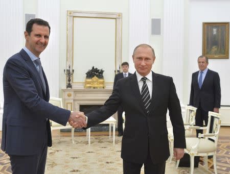 Russian President Vladimir Putin (R) shakes hands with Syrian President Bashar al-Assad during a meeting at the Kremlin in Moscow, Russia, October 20, 2015. REUTERS/Alexei Druzhinin/RIA Novosti/Kremlin