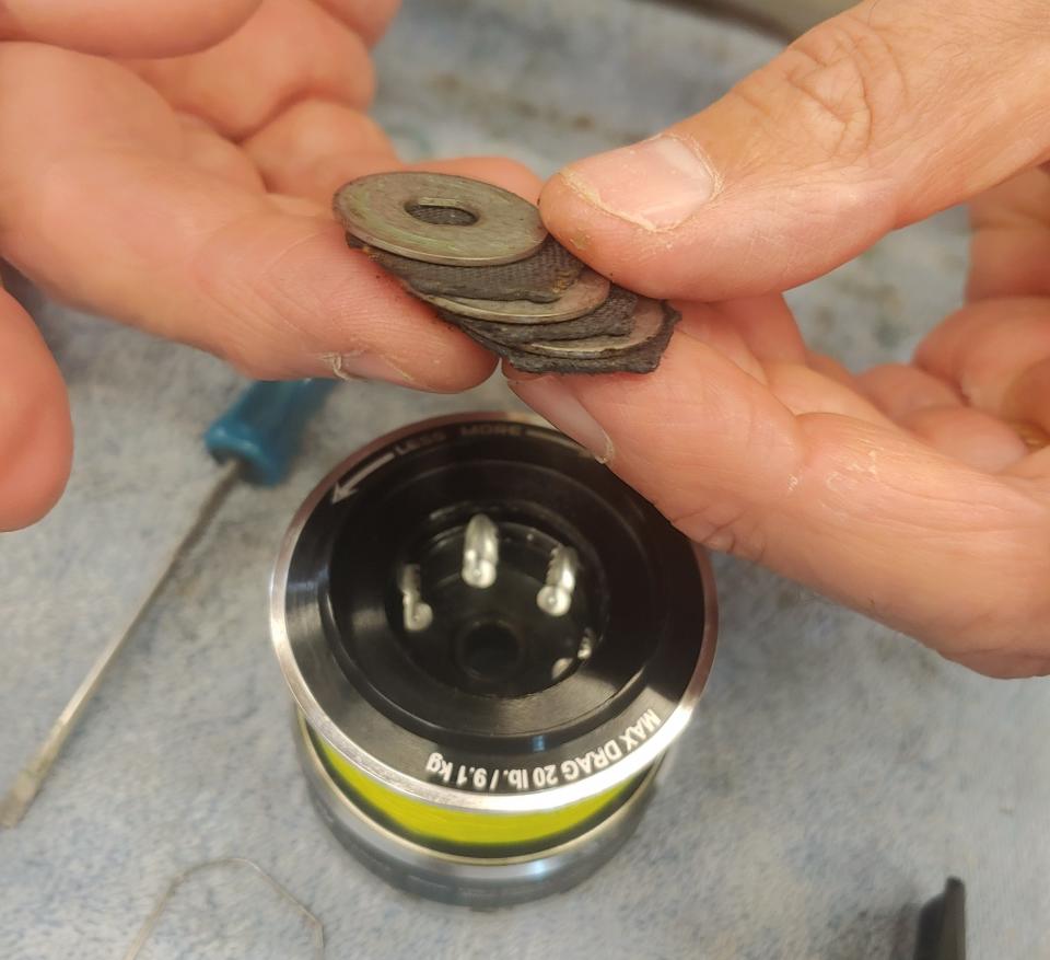 Remove the drag cap and you'll see a thin metal ring that holds the drag washers in place. With any luck, you'll never need to go that deep.