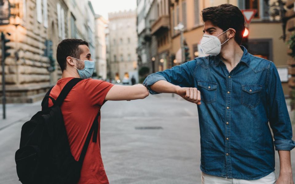 tourists elbow bump - Getty