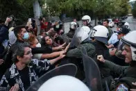 <p>Demonstrators scuffle with riot police, during a protest following the death of Mahsa Amini, outside the Iranian Embassy, in Athens, Greece, September 22, 2022. REUTERS/Costas Baltas</p> 