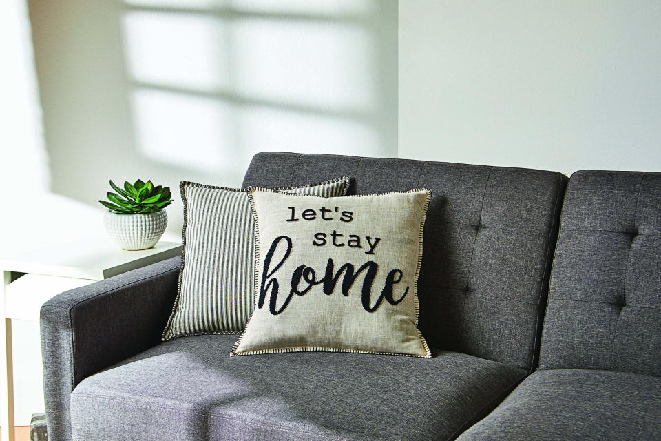 The pillow, which reads "let's stay home"