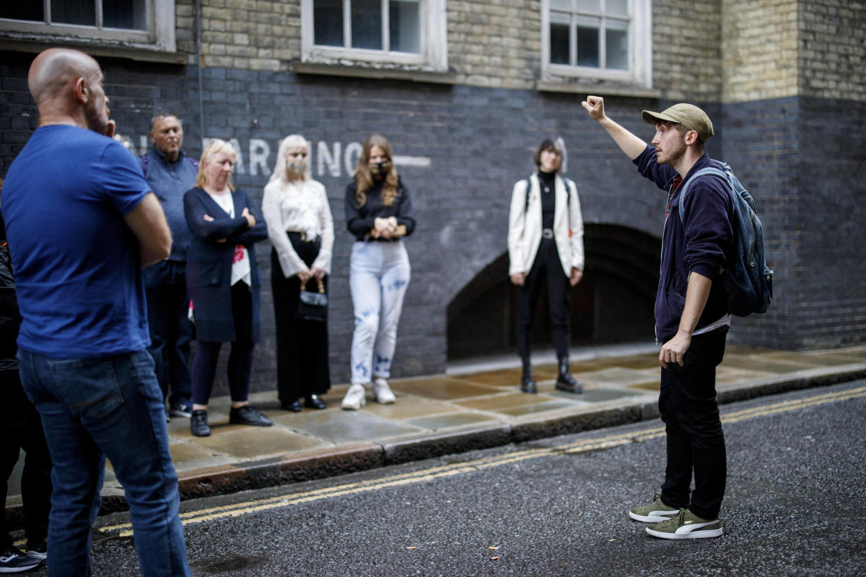 Un guide touristique dirigeant un groupe de touristes lors d’une visite dans les traces de Jack l’éventreur, à Londres, le 24 août 2020.