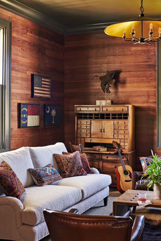 <p>Alison Gootee</p> While the couple chose to brighten much of the home's original wood paneling with paint, they kept it as it was in Jodah's study.