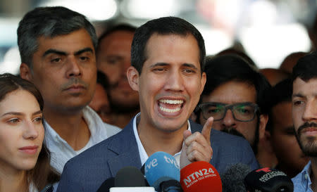 Venezuelan opposition leader Juan Guaido, who many nations have recognized as the country's rightful interim ruler, talks to the media after attending a religious event in Caracas, Venezuela February 10, 2019. REUTERS/Carlos Garcia Rawlins