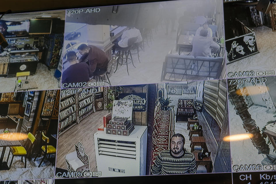 Safaa Rashid looks into a security camera in a Baghdad cafe, Monday, Feb. 27, 2023. The 26-year-old was a child when the Americans arrived in 2003, but he said he rues "the loss of a state, a country that had law and establishment." (AP Photo/Jerome Delay)