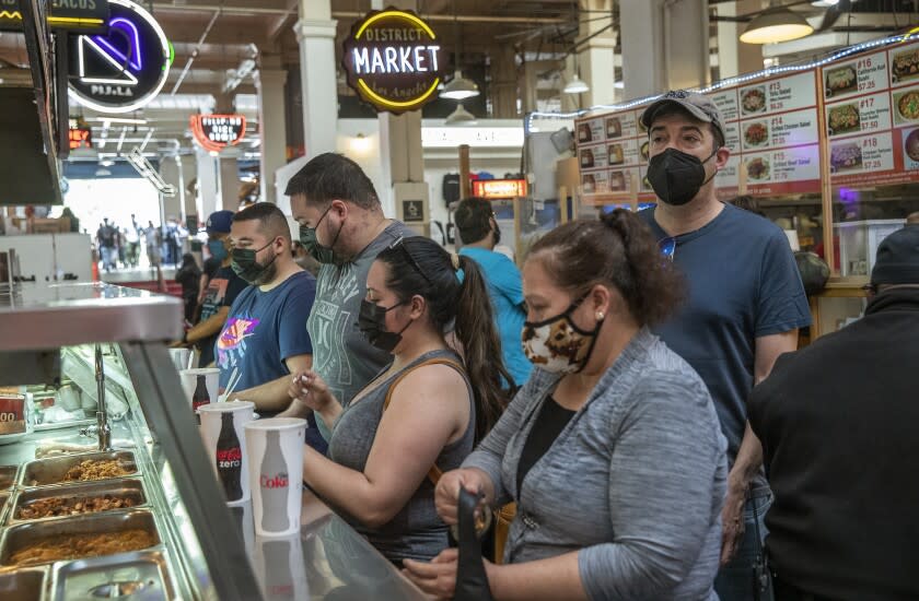 LOS ANGELES, CA - MAY 14, 2021: Customers wait in line to order Mexican food inside the Grand Central Market on Broadway in downtown Los Angeles. The CDC says people fully vaccinated against COVID-19 do not need to wear masks indoors or outdoors in most situations but California hasn't relaxed its rules just yet. (Mel Melcon / Los Angeles Times)