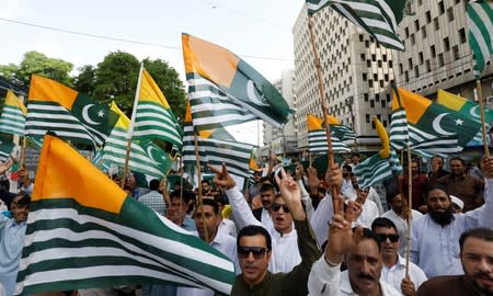 People carry Azad Kashmir's flags and chant slogans over India's decision to revoke the special status of Jammu and Kashmir, during a protest in Karachi