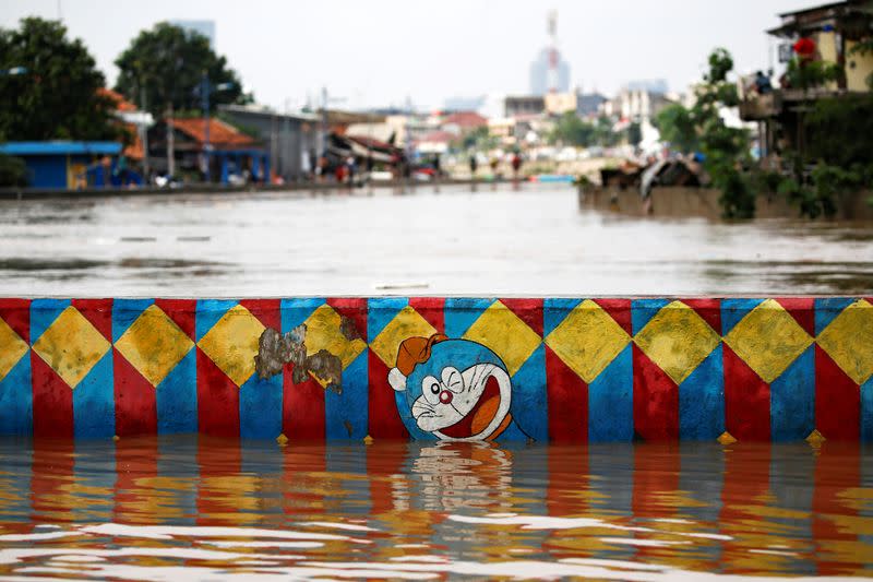 A Doraemon mural is partially submerged in floodwaters in the Jatinegara area after heavy rains in Jakarta