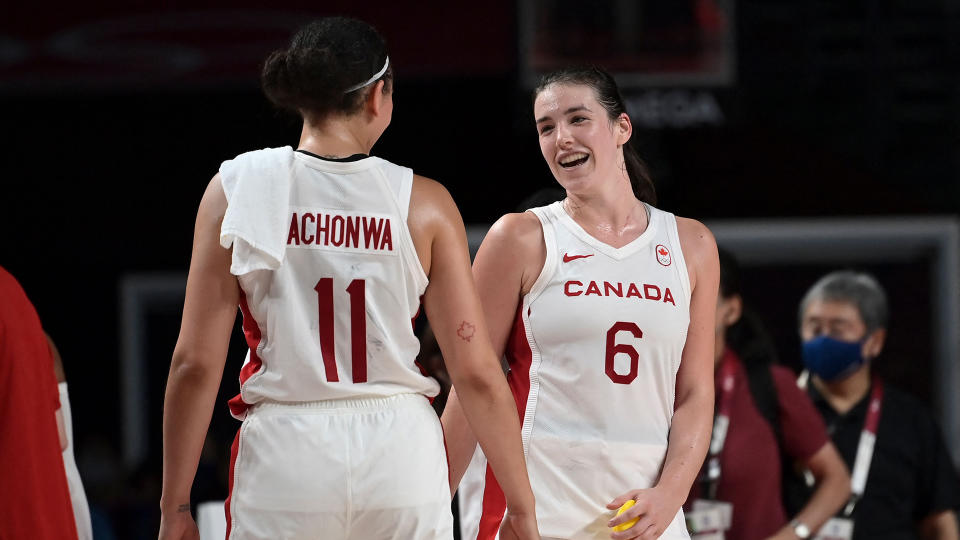 Canada's Natalie Achonwa and Bridget Carleton react after their victory.  (Photo by Aris MESSINIS / AFP)