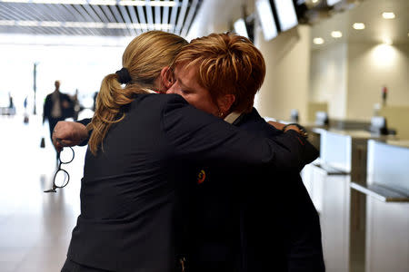 A member of the staff hugs her colleague after a ceremony at Brussels Airport as the departure hall reopens 40 days after deadly attacks, in Zaventem, Belgium, May 1, 2016. REUTERS/Eric Vidal