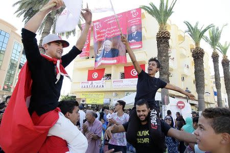 Supporters of the Nida Tounes (Call of Tunisia) secular party movement wave flags while celebrating during the party's election campaign in Tunis October 21, 2014. REUTERS/Anis Mili