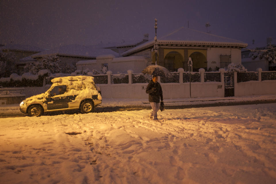 A man walks through a street covered with snow in the city of Ronda, southern Spain, Thursday, Jan. 19, 2017. The schools of Ronda, one of the most historical towns of Andalusia, suspended their classes Thursday and traffic has been interrupted on several highways due to the intense snowfall that has fallen during the night. A cold spell has reached Europe with temperatures plummeting far below zero. (AP Photo/Javier Gonzalez)