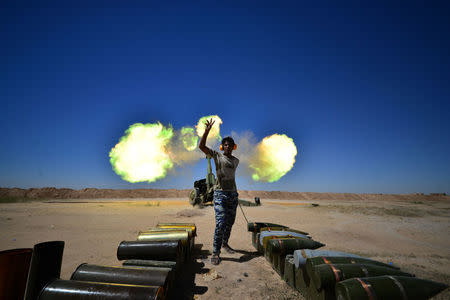 Iraqi paramilitary troops fire towards Islamic State militants during a battle with Islamic State militants on the outskirts of the ancient city of Hatra near Mosul,Iraq April 26, 2017. REUTERS/Stringer