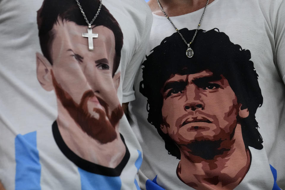 Fans of Argentina wear t-shirts of Lionel Messi, left, and Diego Maradona prior to the World Cup semifinal soccer match between Argentina and Croatia at the Lusail Stadium in Lusail, Qatar, Tuesday, Dec. 13, 2022. (AP Photo/Natacha Pisarenko)