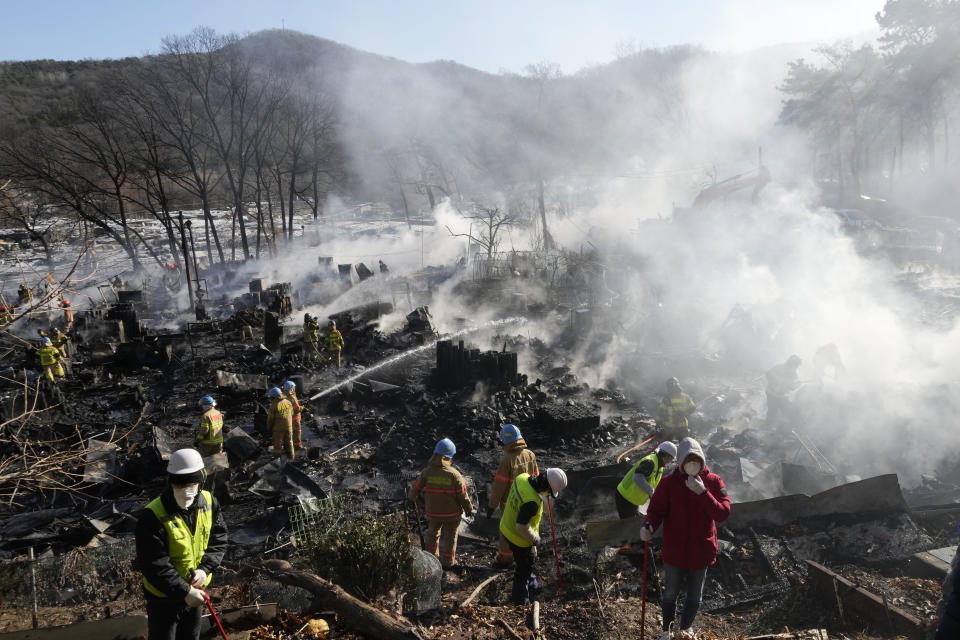 Firefighters and rescue workers clean up the site of a fire at Guryong village in Seoul, South Korea, Friday, Jan. 20, 2023. A fire spread through a neighborhood of densely packed, makeshift homes in South Korea's capital Friday morning. (AP Photo/Ahn Young-joon)