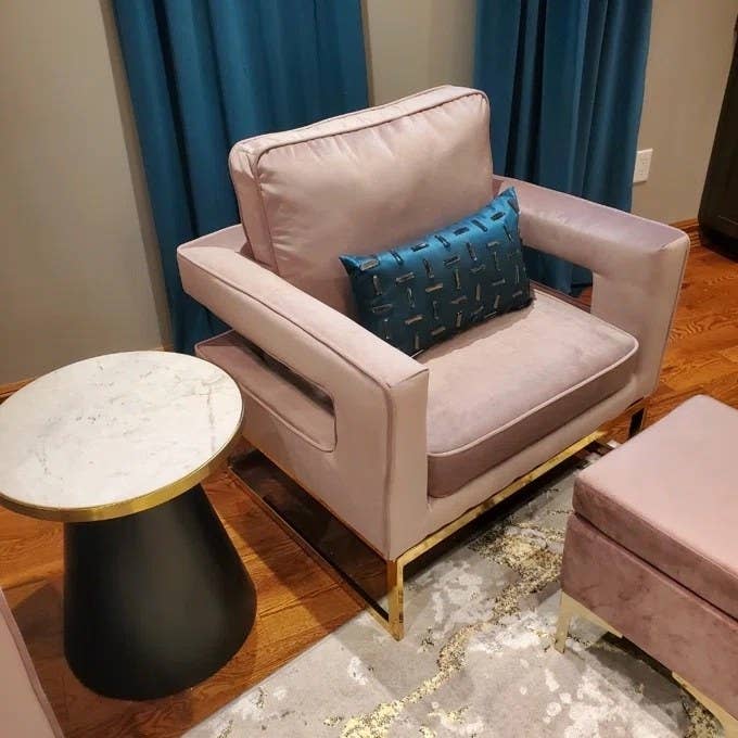 A pink chair with blue cushion in reviewer's home