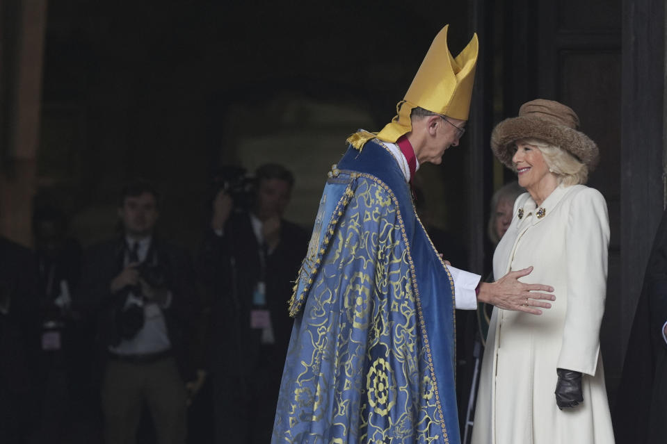 Britain's Queen Camilla, right is greeted by the Bishop of Worcester, John Inge, as she arrives for the Royal Maundy service at Worcester Cathedral, in Worcester, England, Thursday March 28, 2024.( Jacob King/PA via AP)