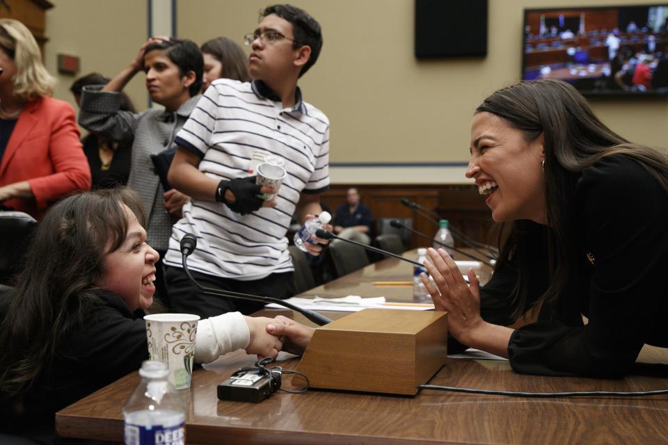 Maria Isabel Bueso, 24, of Concord, Calif., left, shakes hands with Rep. Alexandria Ocasio-Cortez, D-N.Y., after Bueso, who has a rare disease and needs life saving treatments that are unavailable in her home country of Guatemala, testified at a House Oversight subcommittee hearing into the Trump administration's decision to stop considering requests from immigrants seeking to remain in the country for medical treatment and other hardships, Wednesday, Sept. 11, 2019, in Washington. Behind Bueso is Jonathan Sanchez, 16, of Boston, who has cystic fibrosis and was also on the panel. (AP Photo/Jacquelyn Martin)