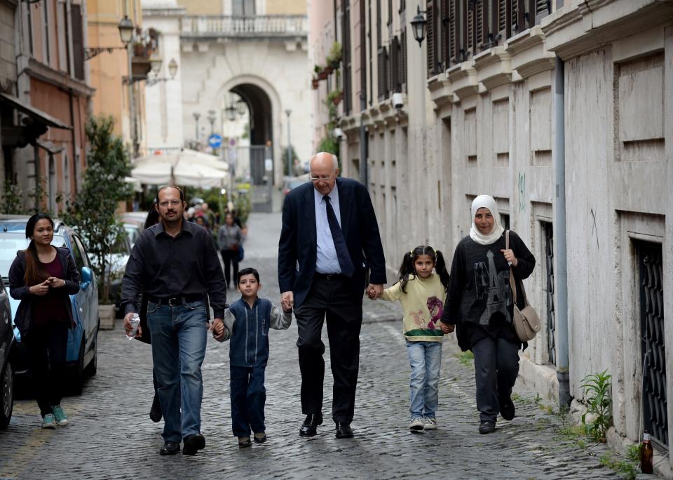 A family of Syrian refugees, part of a group of asylum seekers Pope Francis helped resettle, walks with a member of a Catholic charity on April 18, 2016, in Rome. (Photo: FILIPPO MONTEFORTE via Getty Images)