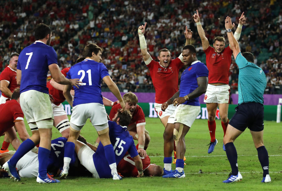 Wales players celebrate after Ross Moriarty scores a try during the Rugby World Cup quarterfinal match against France at Oita Stadium in Oita, Japan, Sunday, Oct. 20, 2019. (AP Photo/Christophe Ena)