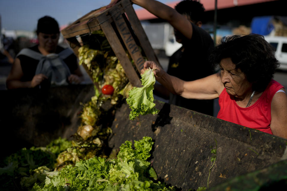 En esta imagen de archivo, una mujer rebusca entre los alimentos descartados por los vendedores de un mercado, a las afueras de Buenos Aires, Argentina, el 10 de enero de 2024. El presidente de Argentina, Javier Milei eliminó los controles de precios y recortó drásticamente las subvenciones, lo que disparó los precios en un país que ya tenía una de las tasas de inflación más altas del mundo. (AP Foto/Natacha Pisarenko, archivo)