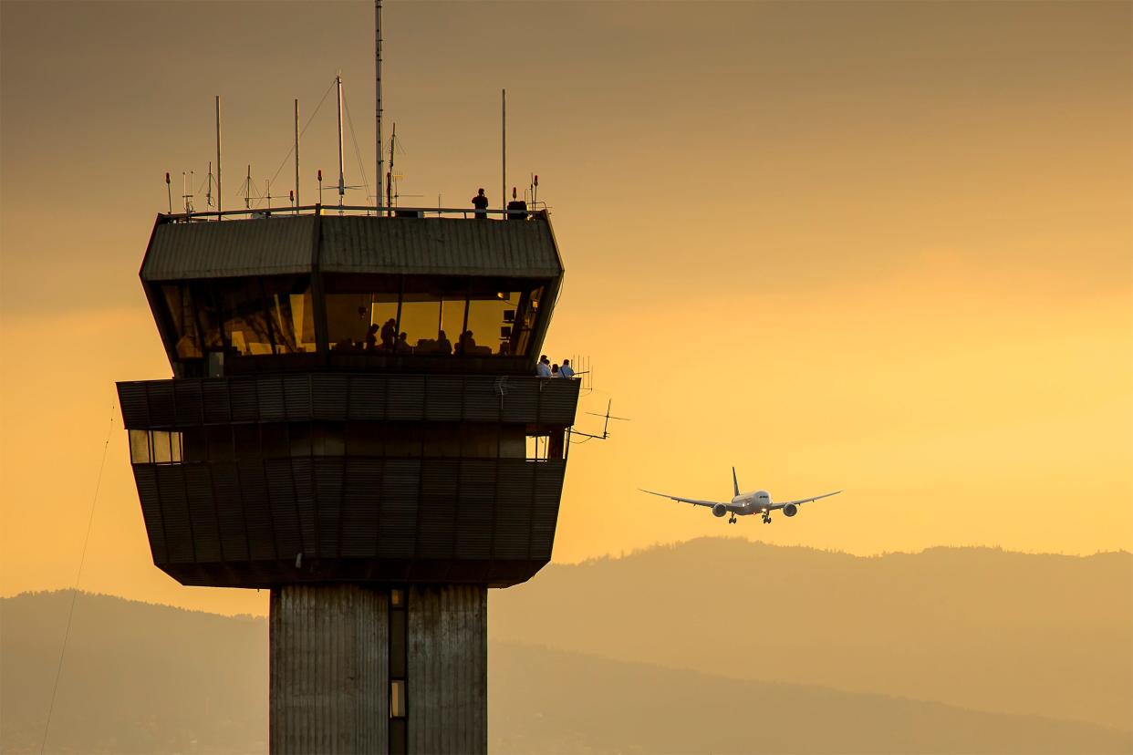 An air traffic control tower at sunset.
