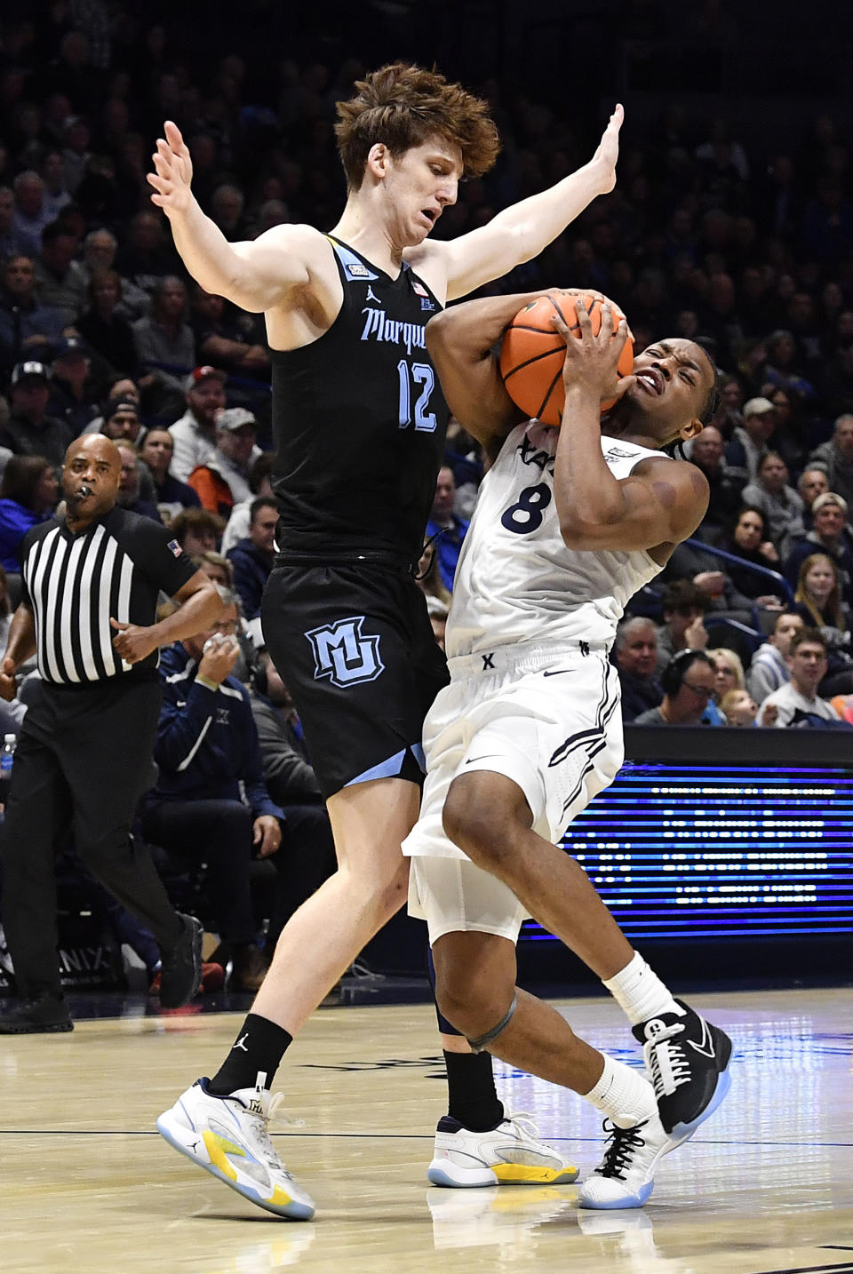 Xavier guard Quincy Olivari (8) makes contact with Marquette forward Ben Gold (12) during the first half of an NCAA college basketball game in Cincinnati, Saturday, March 9, 2024. (AP Photo/Timothy D. Easley)