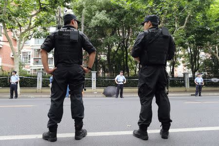 Police officers stand guard at the scene after a man armed with a knife attacked students at the entrance to a primary school, in Xuhui district of Shanghai, China June 28, 2018. REUTERS/Stringer