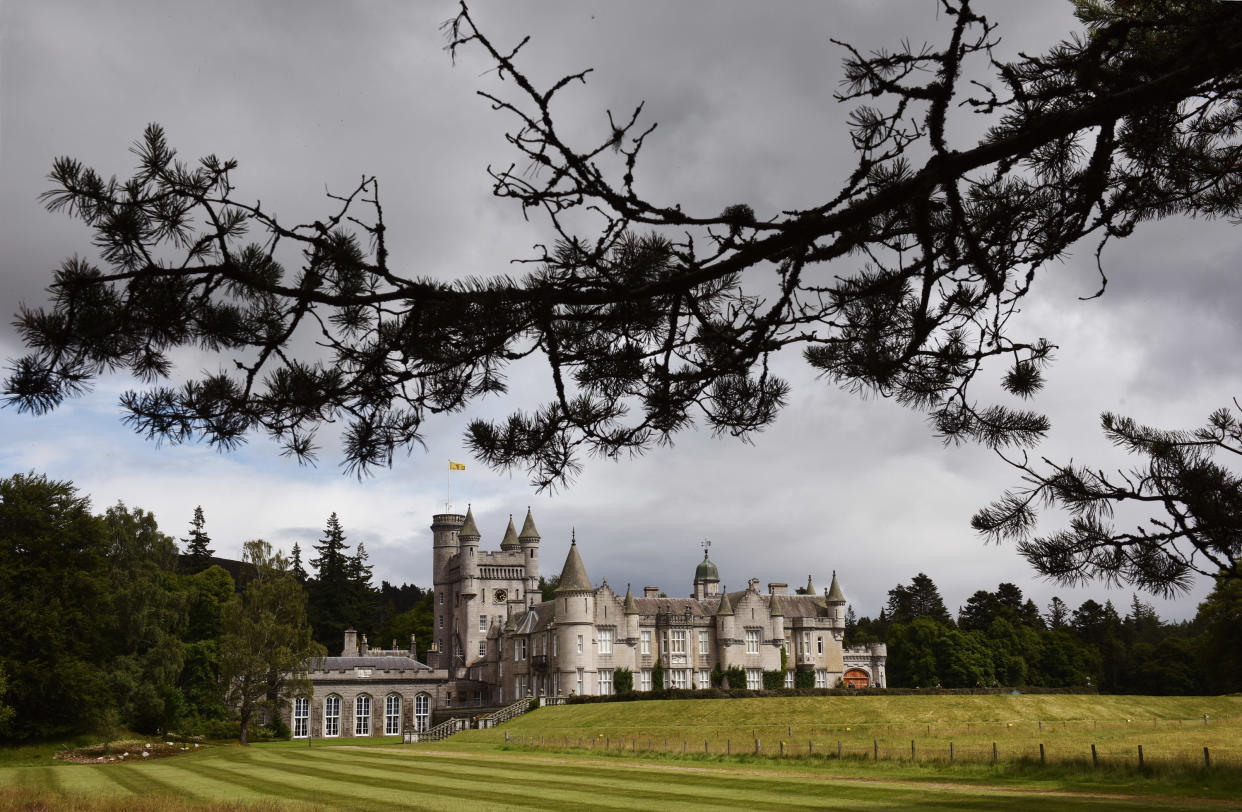 Crathie, UK - July 29th 2015: Scottish fir trees frame the distant view of Balmoral Castle.