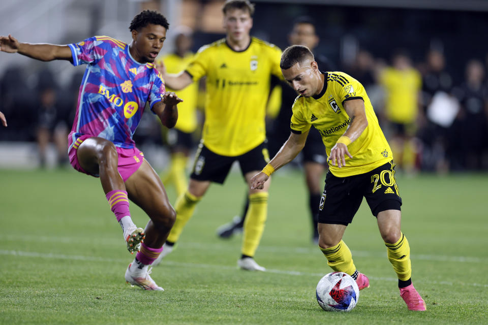 Columbus Crew's Alexandru Matan, right, controls the ball as Toronto FC's Kosi Thompson, left, defends during the second half of an MLS soccer match Saturday, Aug. 26, 2023, in Columbus, Ohio. (AP Photo/Jay LaPrete)