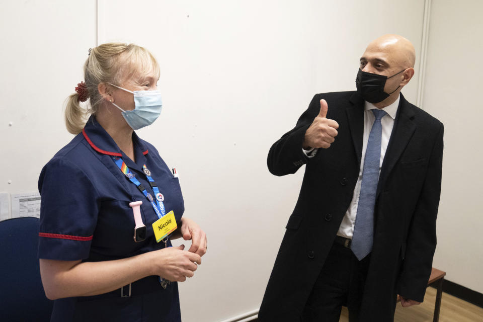 Britain's Health Secretary Sajid Javid meets staff during a visit to a coronavirus vaccination clinic at the Gordon Hospital in Westminster, central London, Wednesday Dec. 15, 2021. Long lines formed outside vaccination centers across England for a second consecutive day on Tuesday as the National Health Service raced to meet the government’s target of delivering up to 1 million shots a day, more than double the recent average. (Stefan Rousseau/PA via AP)
