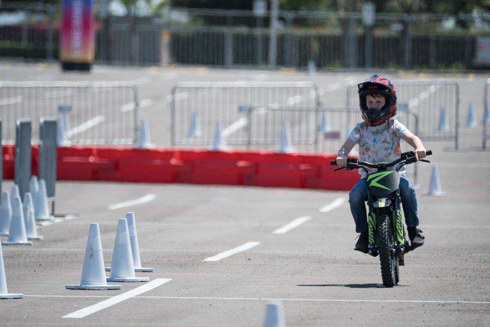 Levi Carmichael, 9, takes a test ride on the Rawrr Mantis Mini electric bike for kids at the Electrify Expo outside State Farm Stadium on May 4, 2024 in Glendale, Ariz.