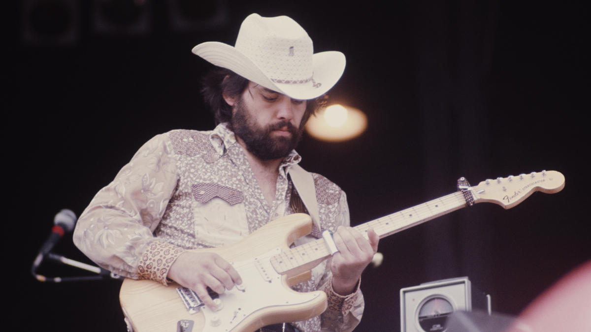  Lowell George playing a Fender Strat while wearing a cowboy hat. 