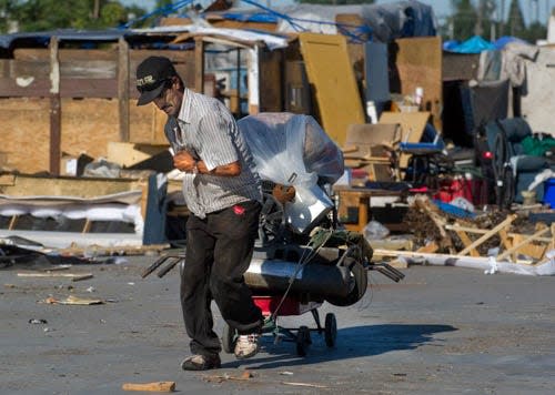 A man who declined to give his name moves some of his belongings July 25 from a homeless encampment on the southwest corner of Hazleton Avenue and Aurora Street in Stockton. About 40 people in approximately 35 handmade structures were evicted from the private lot after notices were given out by the city three days prior. The lot is privately owned, so city code enforcement hired a private contractor to clean out the site and a lien will be placed on the owner to pay for the services. CLIFFORD OTO/THE RECORD